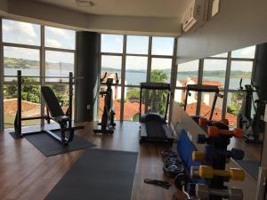 a gym with exercise equipment and a large window at Racini Suites Hotel in Boa Esperança