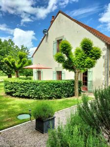 a white house with a tree in the yard at Domaine Pouzoult, gîte l'Escalier in Sazeray