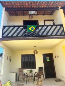 a house with a dog sitting in front of it at Casa à Beira Mar em Praia Seca Araruama RJ in Araruama