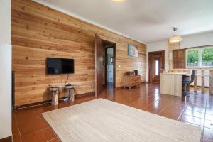 a living room with wooden walls and a flat screen tv at Quinta de Carvalhal - Casa da Vinha in Guimarães