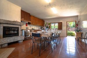 a kitchen with a table and chairs and a fireplace at Quinta de Carvalhal - Casa da Vinha in Guimarães