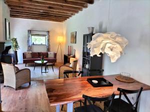 a living room with a wooden table and chairs at Domaine Pouzoult, gîte l'Escalier in Sazeray