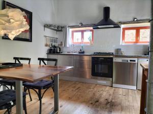 a kitchen with a wooden table and a wooden floor at Domaine Pouzoult, gîte l'Escalier in Sazeray