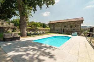 a swimming pool in the backyard of a house at Quinta de Carvalhal - Casa da Vinha in Guimarães