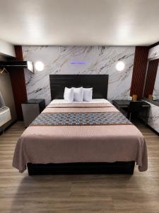 ein Hotelzimmer mit einem großen Bett und zwei Kissen in der Unterkunft Hotel OPUS Bronx Near Bay Plaza Mall in Bronx + 30 Fotos