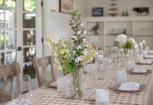 a table with a vase with flowers in it at Farmhouse Inn in Forestville