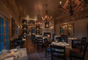 a restaurant with tables and chairs and a fireplace at Farmhouse Inn in Forestville