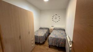 a small room with two beds and a clock on the wall at Casa Entre Riscos in Corejido