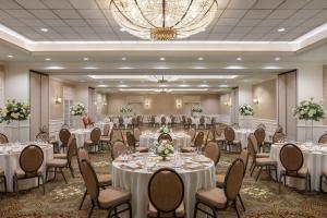 a banquet hall with tables and chairs and a chandelier at Omni La Mansion del Rio in San Antonio +93 photos