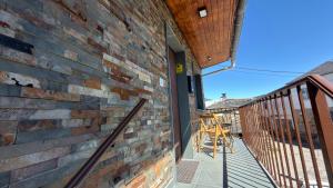a balcony with a brick wall and a wooden chair at Casa Entre Riscos in Corejido