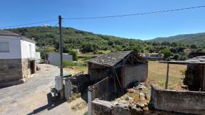 a small building in a village with mountains in the background at Casa Entre Riscos in Corejido +1 photo