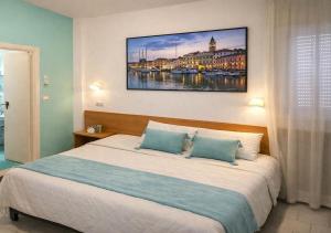 ein Schlafzimmer mit einem Bett und einem Gemälde an der Wand in der Unterkunft Hotel Jasmine Beach in Rimini