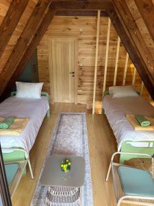 ein Dachzimmer mit zwei Betten und einem Tisch in der Unterkunft Chalet SOFI in Šavnik