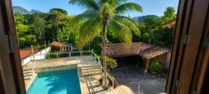 a view of a swimming pool and a palm tree at Casa Country Niterói in Niterói