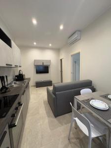 a kitchen and living room with a couch and a table at Casa Varone del Vesuvio in Torre Annunziata