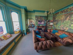 a living room with a brown leather couch at The Sheldon B&B in Eastbourne