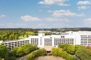 a large white building with trees in front of it at Crowne Plaza Canberra by IHG in Canberra