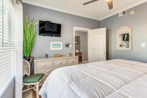 a bedroom with a bed and a tv on a wall at Destin Ground-Level Condo w/ Private Beach Access in Destin +36 photos