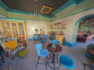 a doll house living room with blue chairs and a table at The Sheldon B&B in Eastbourne