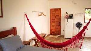 a room with a red hammock in a living room at Chales Paraíso STL in São Thomé das Letras