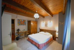 a bedroom with a bed and a table in a room at Logis Hôtel-restaurant La Mère Biquette in Saint-Pons