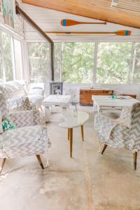 a living room with couches and tables and windows at La Posada del Abra in Tigre