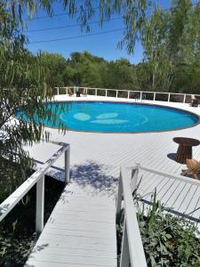 a swimming pool with a wooden walkway leading to a bridge at La Posada del Abra in Tigre