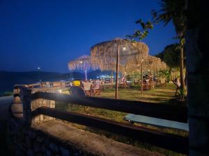 a park with tables and umbrellas at night at Camping Karavomilos in Sami +19 photos