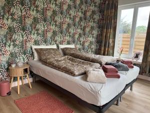 a bed in a room with a floral wallpaper at Maison Frieda in Oostkamp