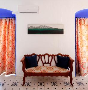 a couch in a room with curtains and a painting at La Estrella de Tarifa in Tarifa