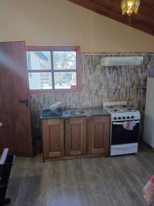 a kitchen with a stove and a sink at Alojamiento Adonai in Tolhuin