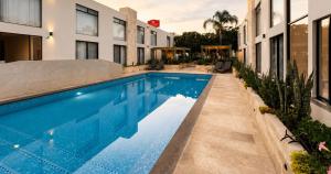 a swimming pool in front of a building at La Posada Hotel y Suites in San Luis Potosí