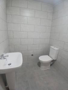 a white bathroom with a toilet and a sink at The Ashington Collection in Ashington