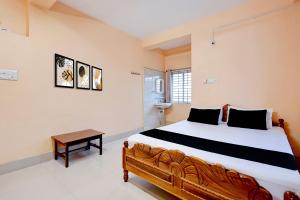 a bedroom with a large bed and a table at Hotel O Snow White in Bhadrak