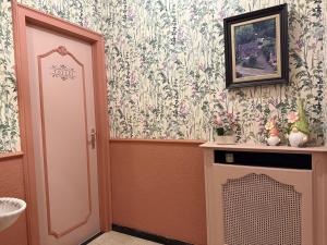 a room with a door and a fireplace with floral wallpaper at Maison Frieda in Oostkamp +57 photos