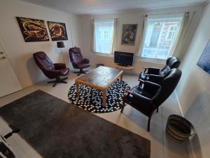 a living room with chairs and a table and a tv at Holiday Hus in Rudkøbing