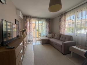 a living room with a couch and a television at Apartamento Pargue Tropical in Los Cristianos
