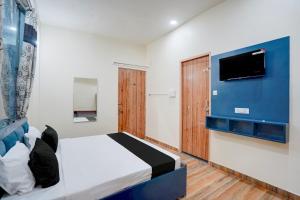 a bedroom with a bed and a flat screen tv at Hotel O Sapphire Grand in Lucknow