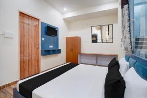 a bedroom with a bed and a tv on the wall at Hotel O Sapphire Grand in Lucknow