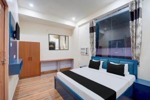 a bedroom with a bed and a large window at Hotel O Sapphire Grand in Lucknow