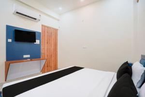 a bedroom with a bed and a tv on the wall at Hotel O Sapphire Grand in Lucknow