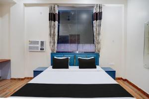 a bedroom with a blue and white bed with two pillows at Hotel O Sapphire Grand in Lucknow +28 photos