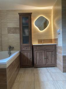 a bathroom with a tub and a sink and a mirror at Chalupa Na konci Lhoty in Pluhův Žďár