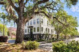 a white building with a tree in front of it at King Suite 2nd FloorHotel Boutique in Savannah