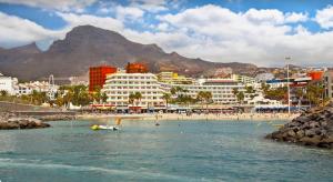 a beach with buildings and people in the water at Apartamento Pargue Tropical in Los Cristianos