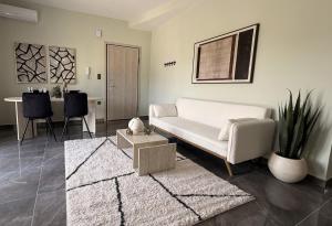 a living room with a white couch and a table at Bistro 49 Luxury suites in Katerini