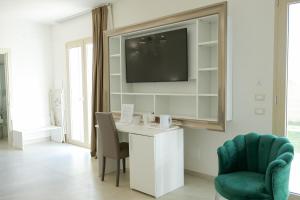 a living room with a desk and a tv on a wall at Masseria Pozzelle in Otranto