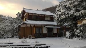 una casa coperta di neve di fronte di Echizen Guesthouse TAMADA a Fukui
