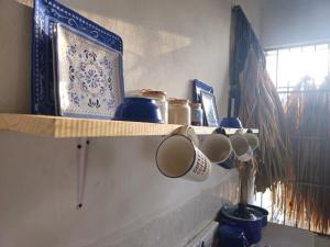 a shelf with cups and other items on it at Casa el Monte in Valladolid