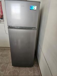 a silver refrigerator sitting in a kitchen next to a wall at Casa el Monte in Valladolid +2 photos